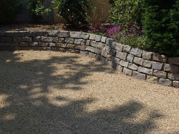 Natursteinmauer aus Muschelkalksteinen - Abdeckmaterial der Zufahrt: gelber Granit-Edelsplitt 8-11